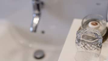 Un lavamanos con una copa de vidrio transparente.
