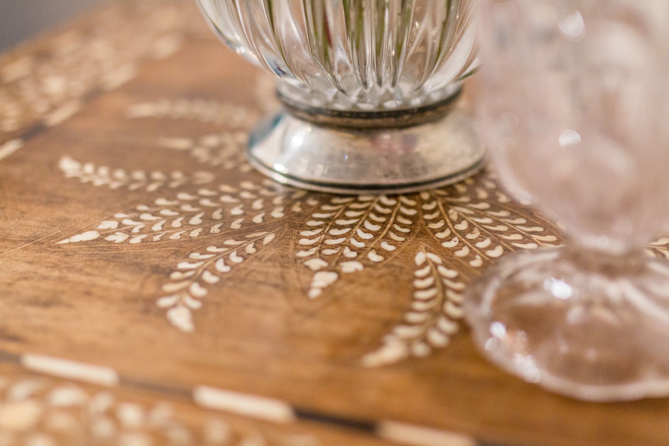 A wooden table with a decorative leaf pattern.