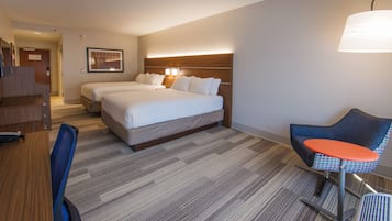 Une chambre d’hôtel avec un lit double, un bureau, une chaise et une lampe.