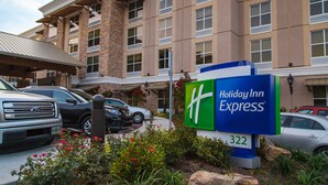 Een Holiday Inn Express gebouw met een bakstenen gevel, meerdere ramen en een bord met het adres 322.