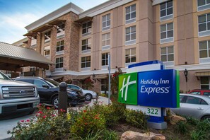 Edifício da Holiday Inn Express com fachada de tijolos, várias janelas e uma placa indicando o número 322.