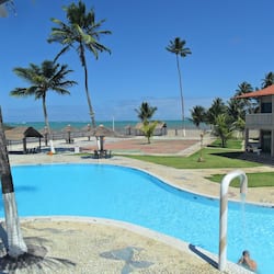 Una piscina al aire libre, sombrillas, sillones reclinables de piscina