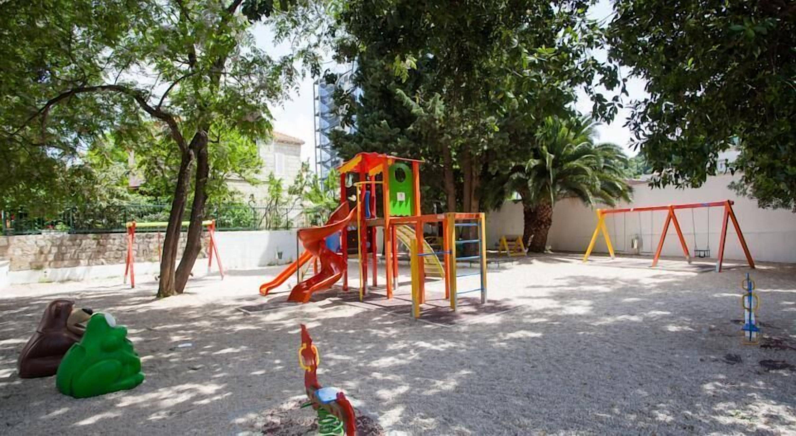 Un parque infantil con tobogán, columpios y estructuras para escalar.