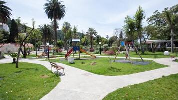 A park with playground equipment, benches, and a walking path.