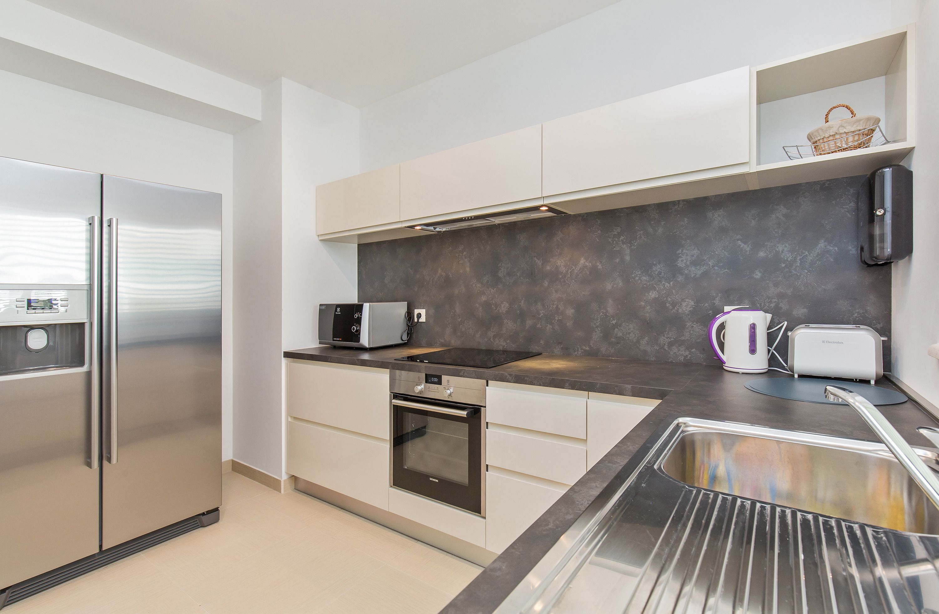 A modern kitchen with stainless steel appliances, a built-in oven, and a microwave.