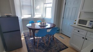 A compact kitchen with a dining area, a microwave, and a refrigerator.