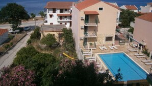 A residential building with a swimming pool, balconies, and a view of the sea. - Petros Studios (Kefalonia)