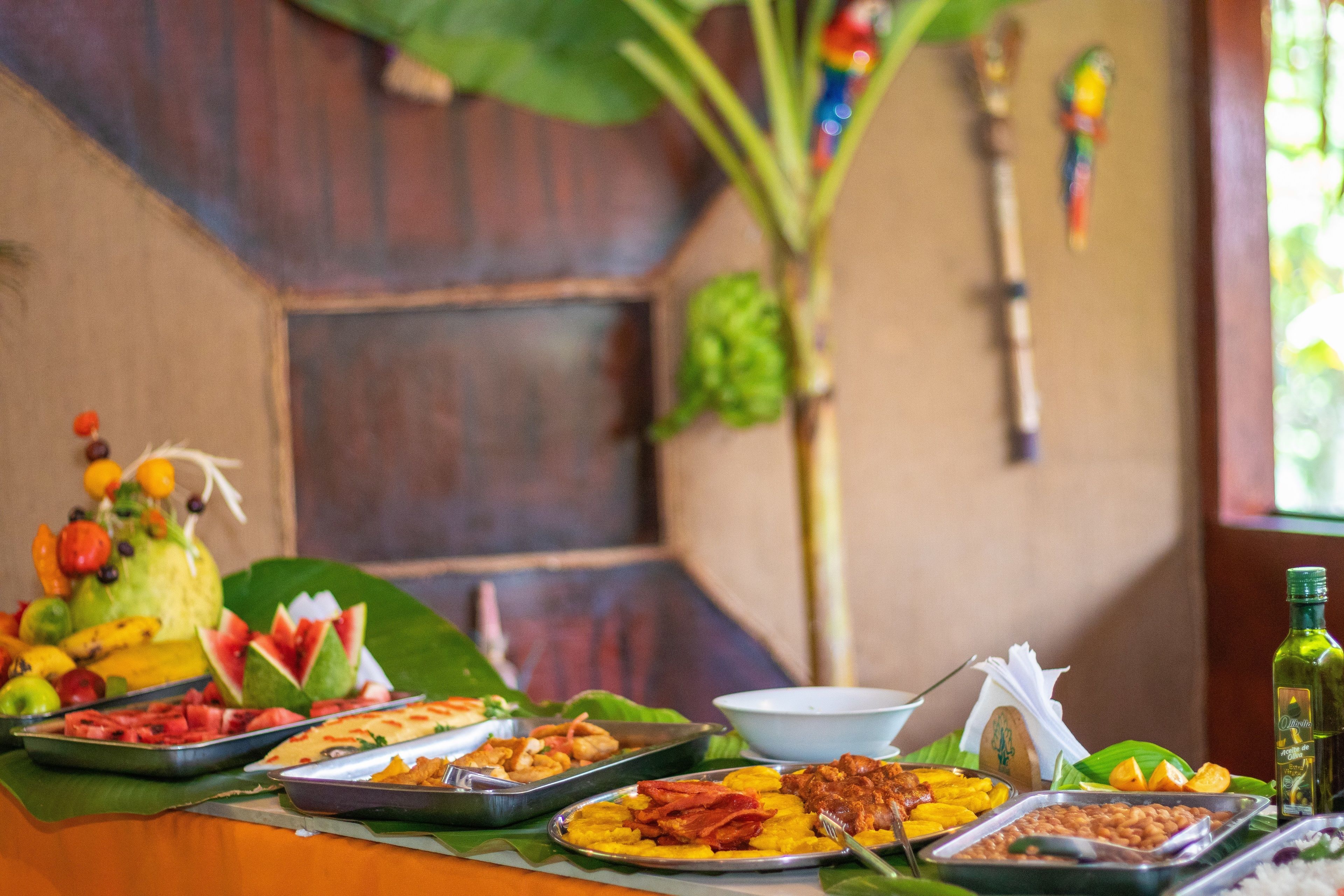 Una mesa de buffet con diferentes platos y una botella de aceite de oliva.