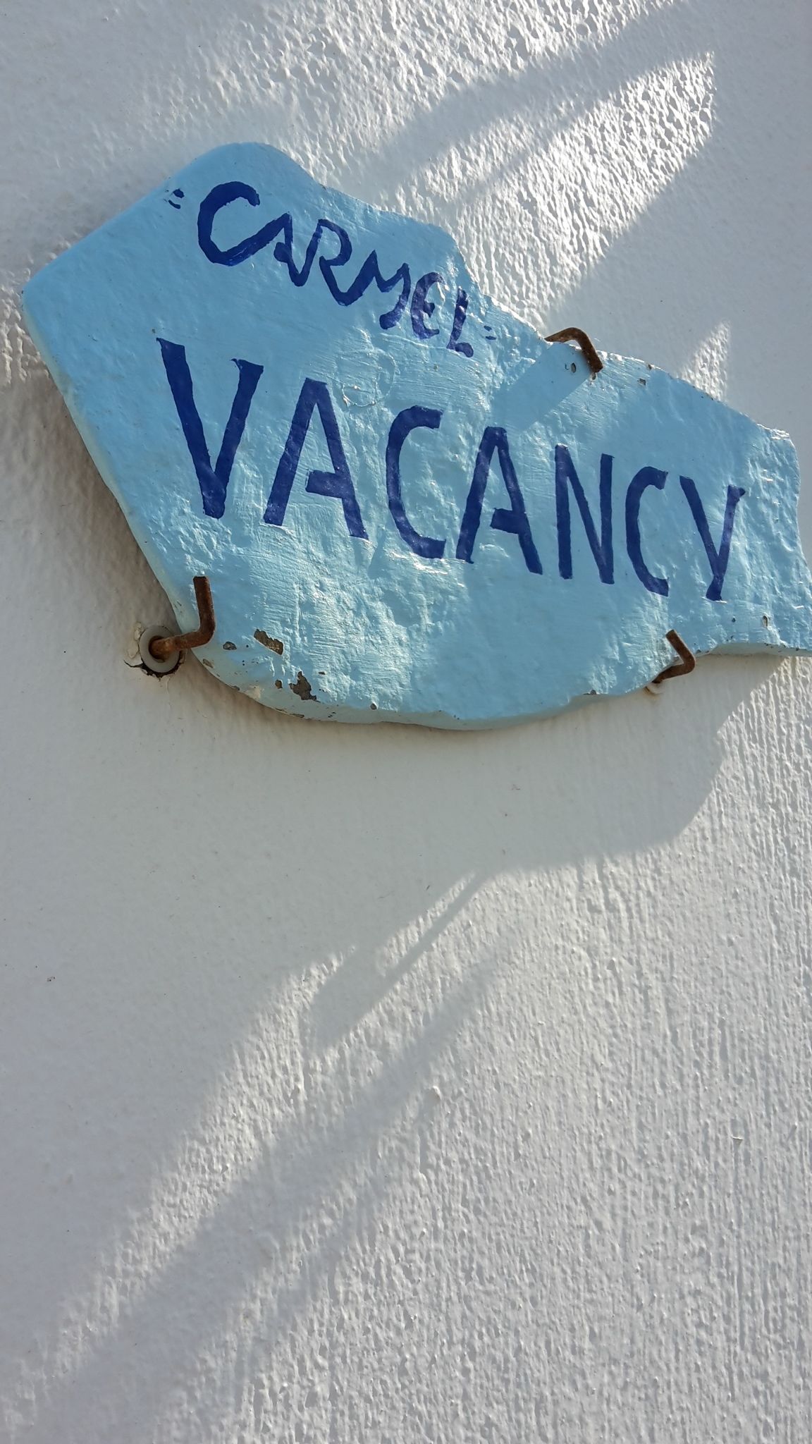 Ein blaues Schild mit der Aufschrift 'CARMEL VACANCY'.