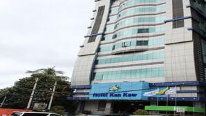 Un hotel de varios pisos con un letrero azul destacado que dice 'Hotel Kan Kaw'.