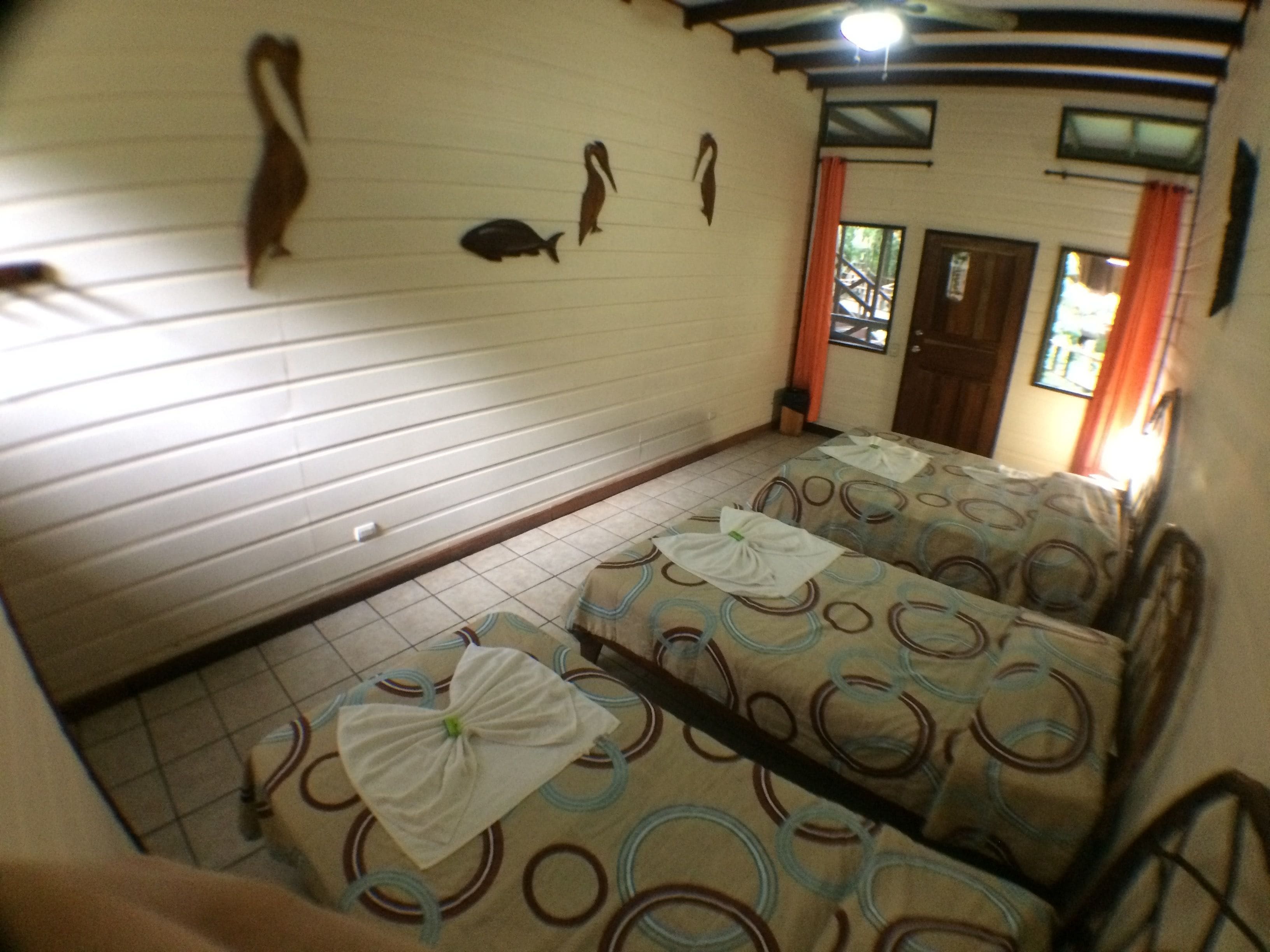 Ein Zimmer mit zwei Betten, Fliesenboden und Wanddekorationen.
