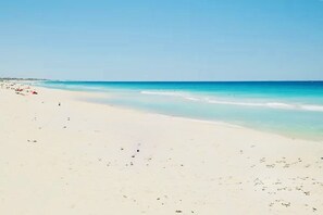 A la platja, platja de sorra blanca i para-sols per a la platja 