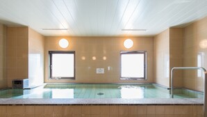 A swimming pool with two large windows, a metal handrail, and a tiled wall. - Tabist Hotel Tetora Kitakyusyu (Kitakyushu)