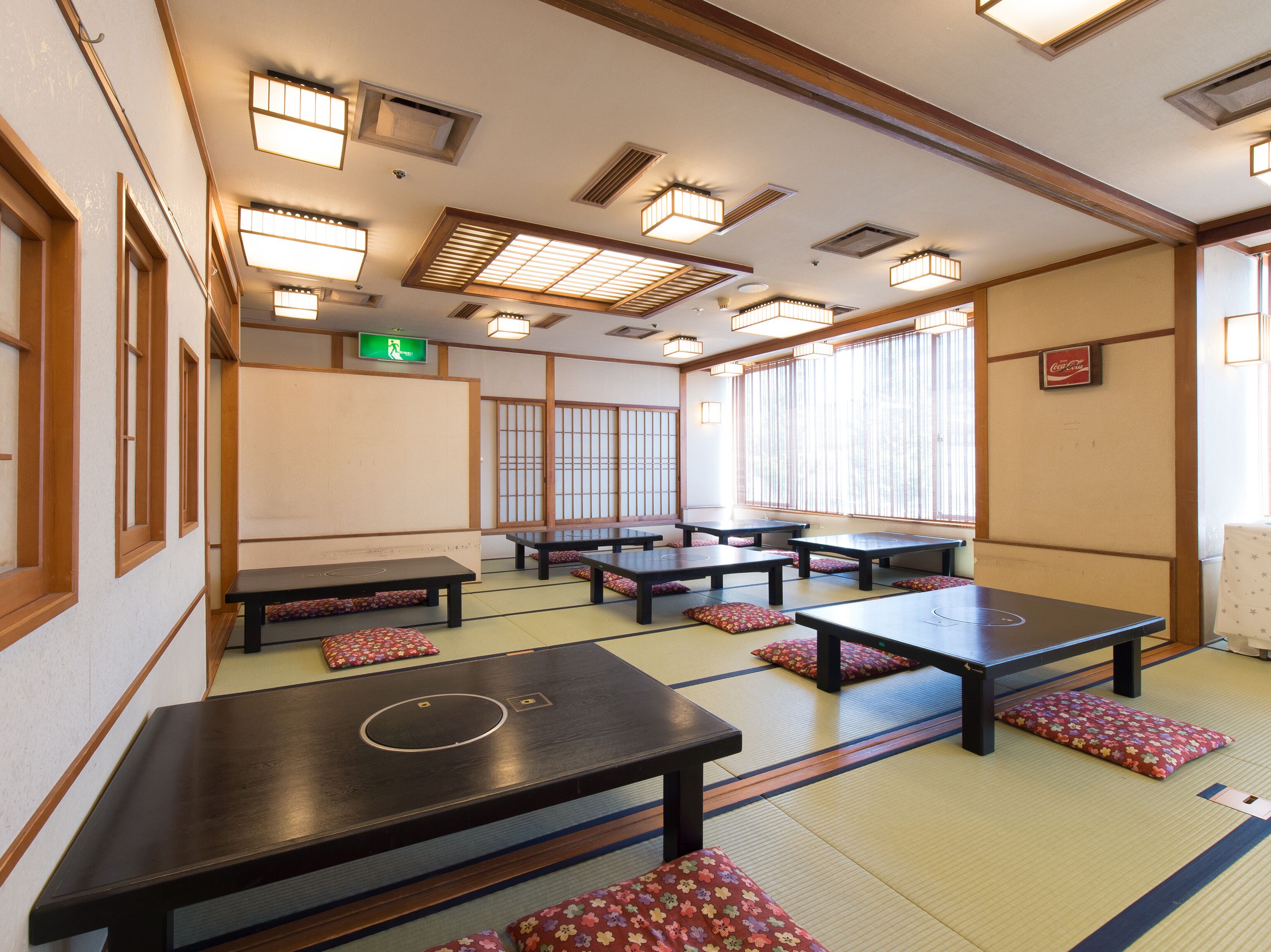 A traditional Japanese room with tatami flooring, low tables, and shoji screens.