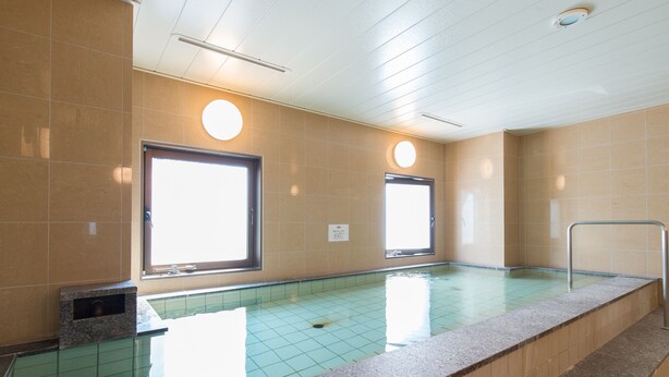 A swimming pool with tiled walls and a tiled floor, two windows, and a metal handrail along the pool edge. - Tabist Hotel Tetora Kitakyusyu (Kitakyushu)