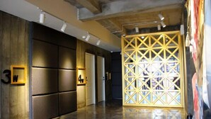 A hallway with a wooden wall, a geometric partition, and a number sign '3W' on the left.