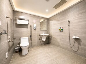 Een moderne badkamer met toilet, toiletbrons, wastafel en douche.