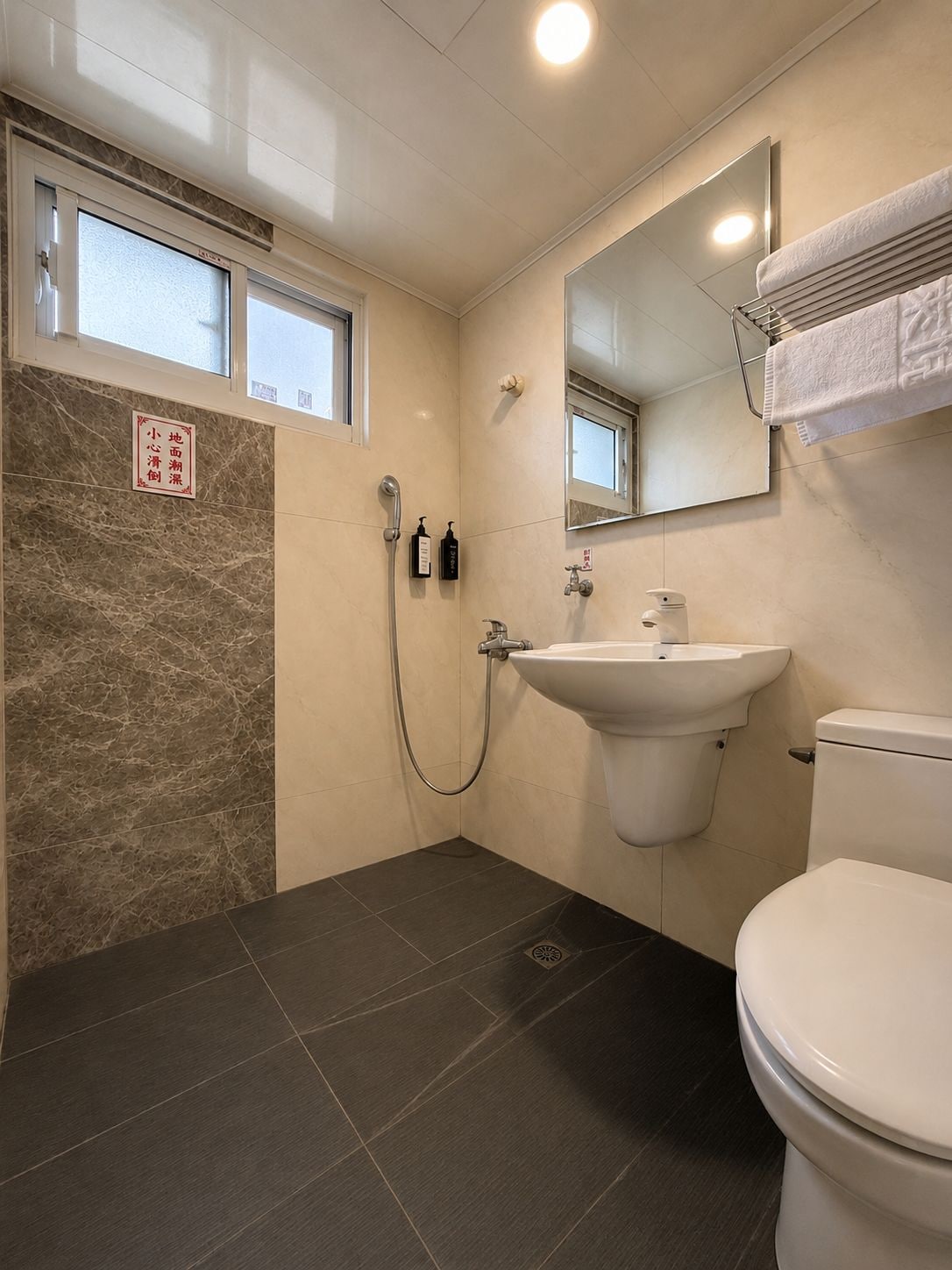 A bathroom with a shower, sink, and toilet.