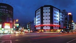 Un hôtel à plusieurs étages au design moderne, caractérisé par une façade rouge et blanche très visible.