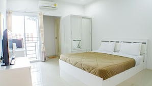 A hotel room with a bed, a wardrobe, a television, and a sliding door to a balcony. - Be My Guest (Ubon Ratchathani)