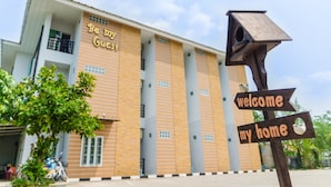 A building with a sign reading "Be my Guest" and a wooden signpost with "welcome my home" and a birdhouse. - Be My Guest (Ubon Ratchathani)