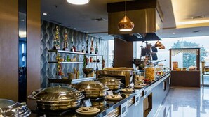 A buffet area with a variety of dishes and a decorative wall with trophies. - Beston Hotel Palembang (Palembang)