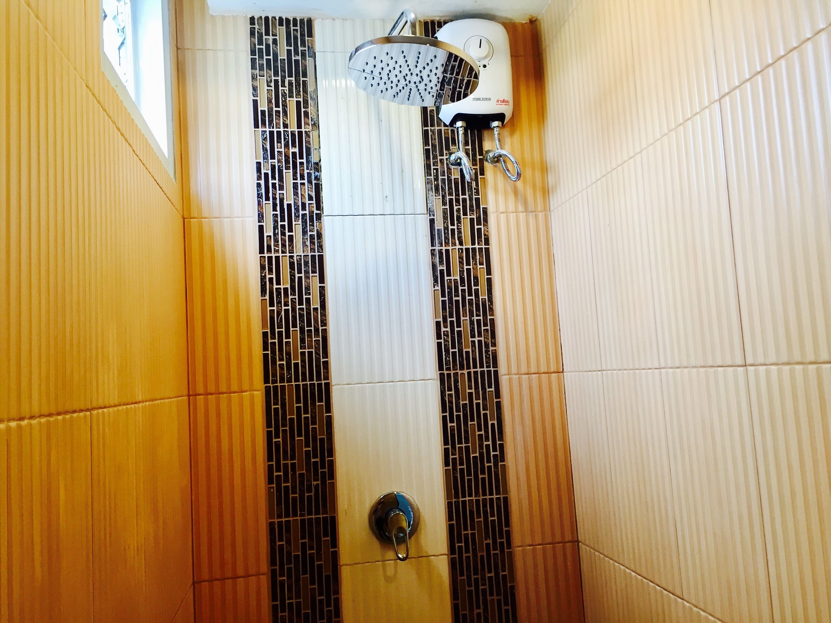 A shower with a rain showerhead and a control knob.