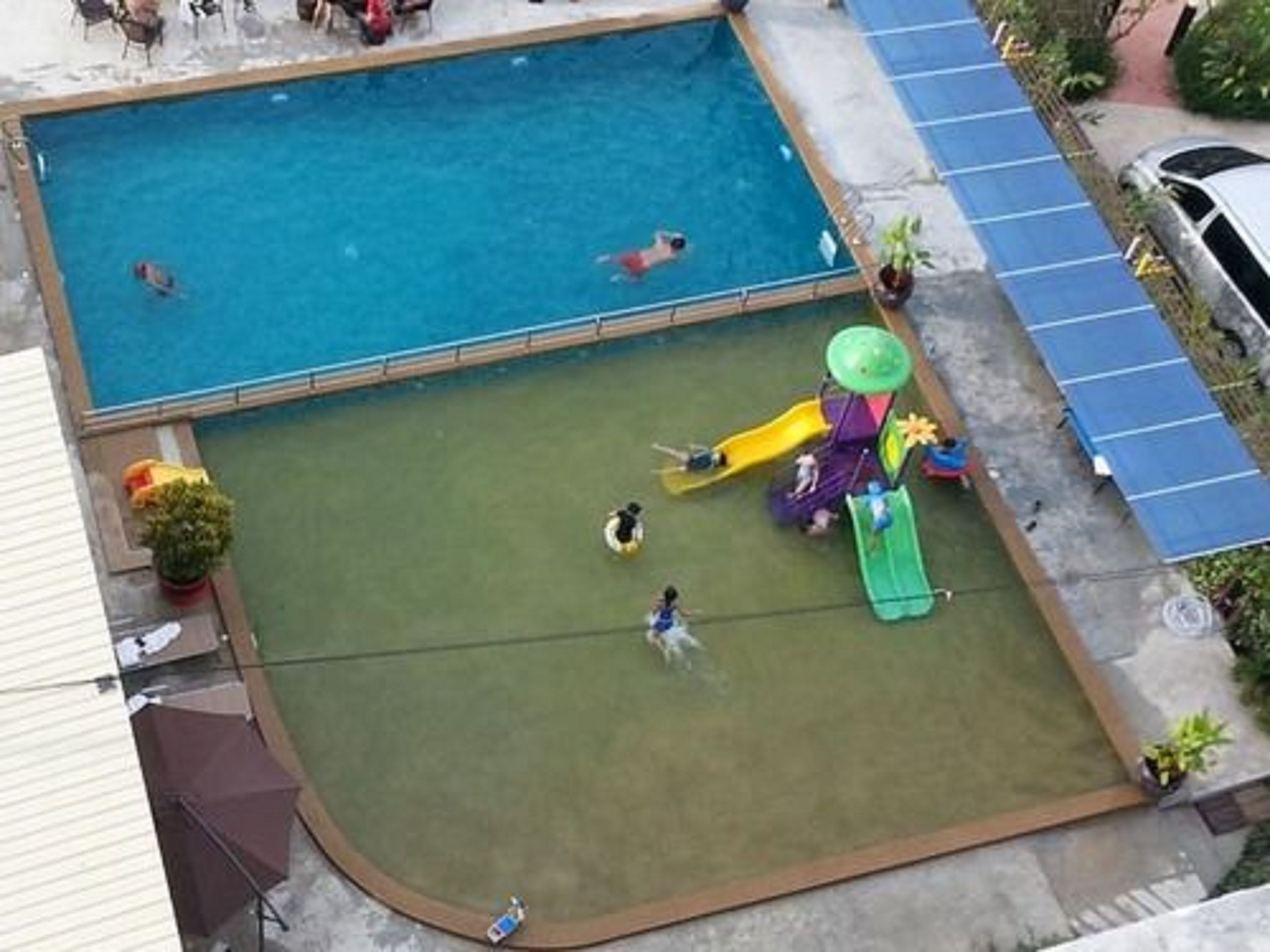 Una piscina al aire libre, sillones reclinables de piscina