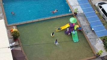 Una piscina al aire libre, sillones reclinables de piscina
