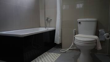 A bathroom with a bathtub, toilet, and shower.