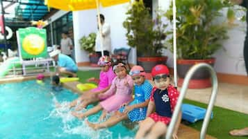 Una piscina al aire libre, sillones reclinables de piscina