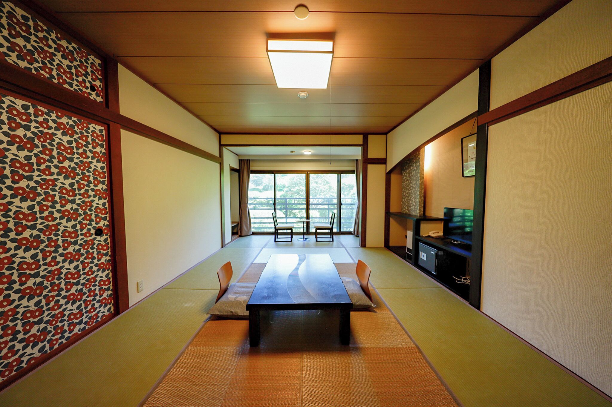 A traditional Japanese room with tatami flooring, a low table, and sliding doors.