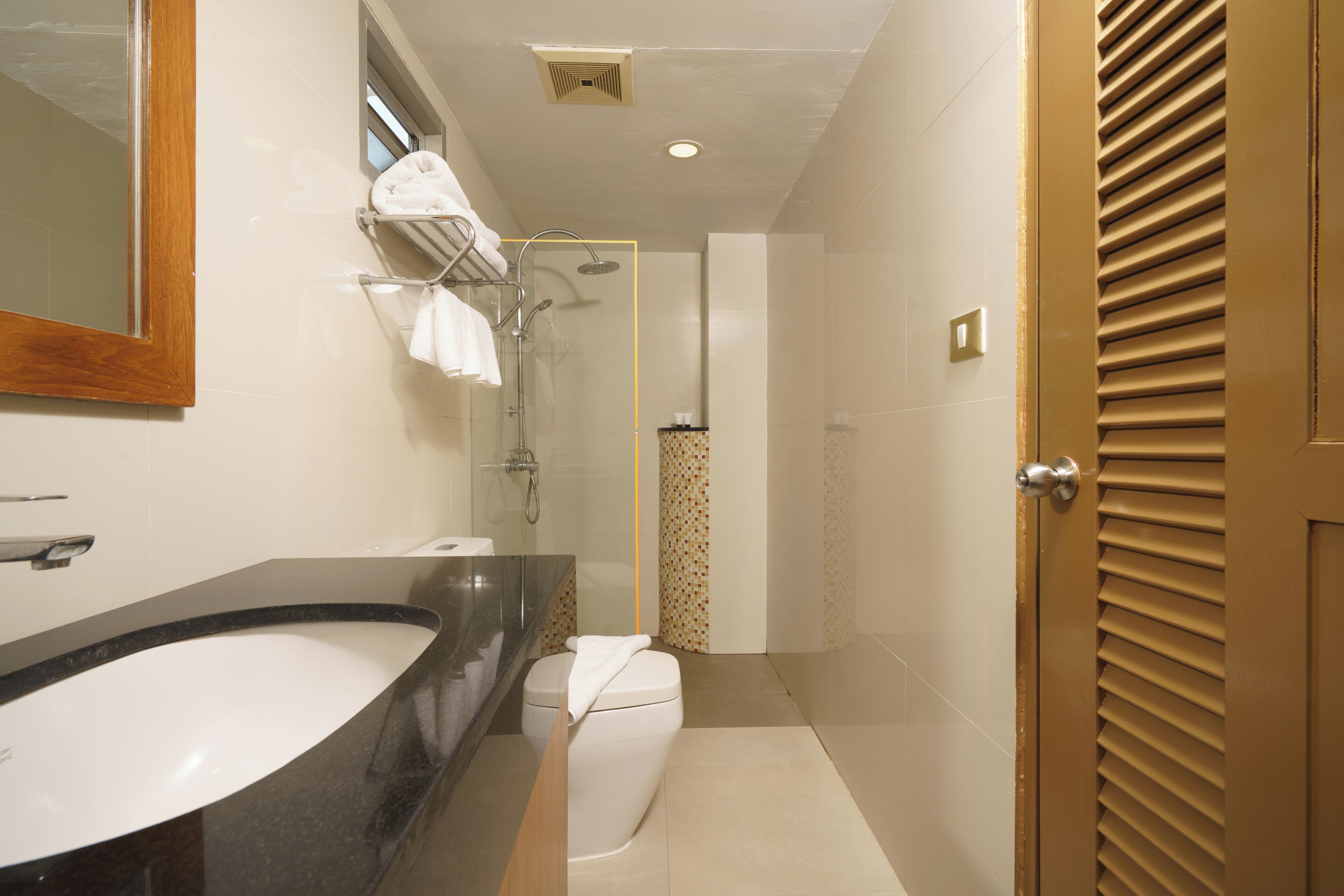 Un baño moderno con un lavamanos grande, inodoro y ducha.