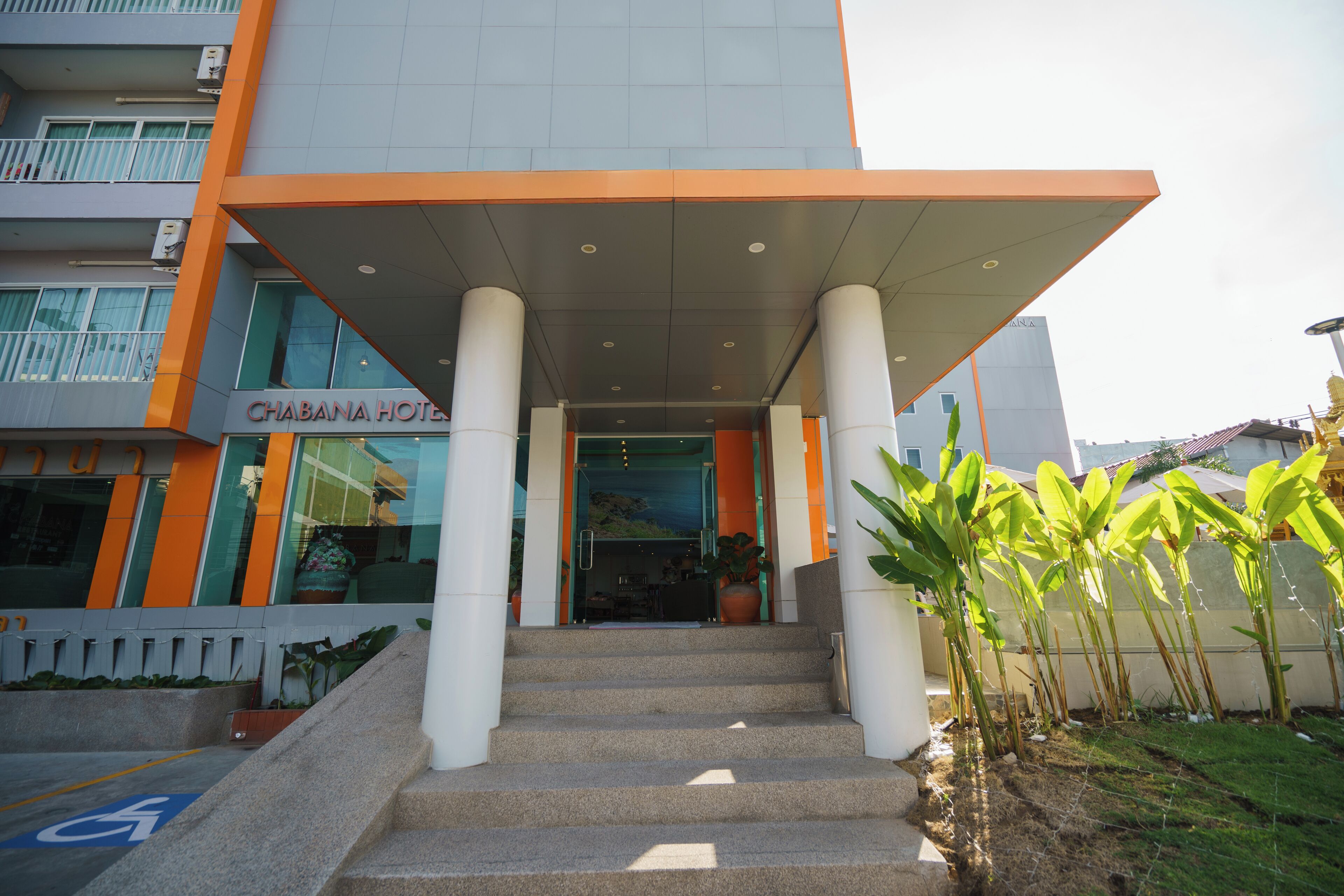 A hotel entrance with a ramp and steps, a wheelchair-accessible path, and a sign for 'Chabana Hotel'.