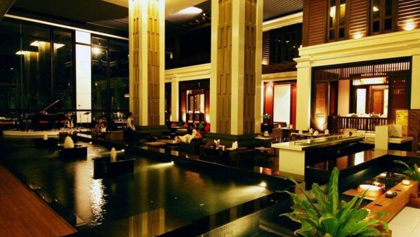 A spacious indoor area with a central water feature, seating arrangements, and a bar area. - Sunee Grand Hotel (Ubon Ratchathani)
