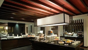 A buffet setup with various food items and a modern interior design.