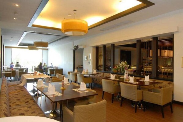 Un comedor espacioso con mesas largas, asientos cómodos, ventanas amplias y un diseño de interiores moderno.