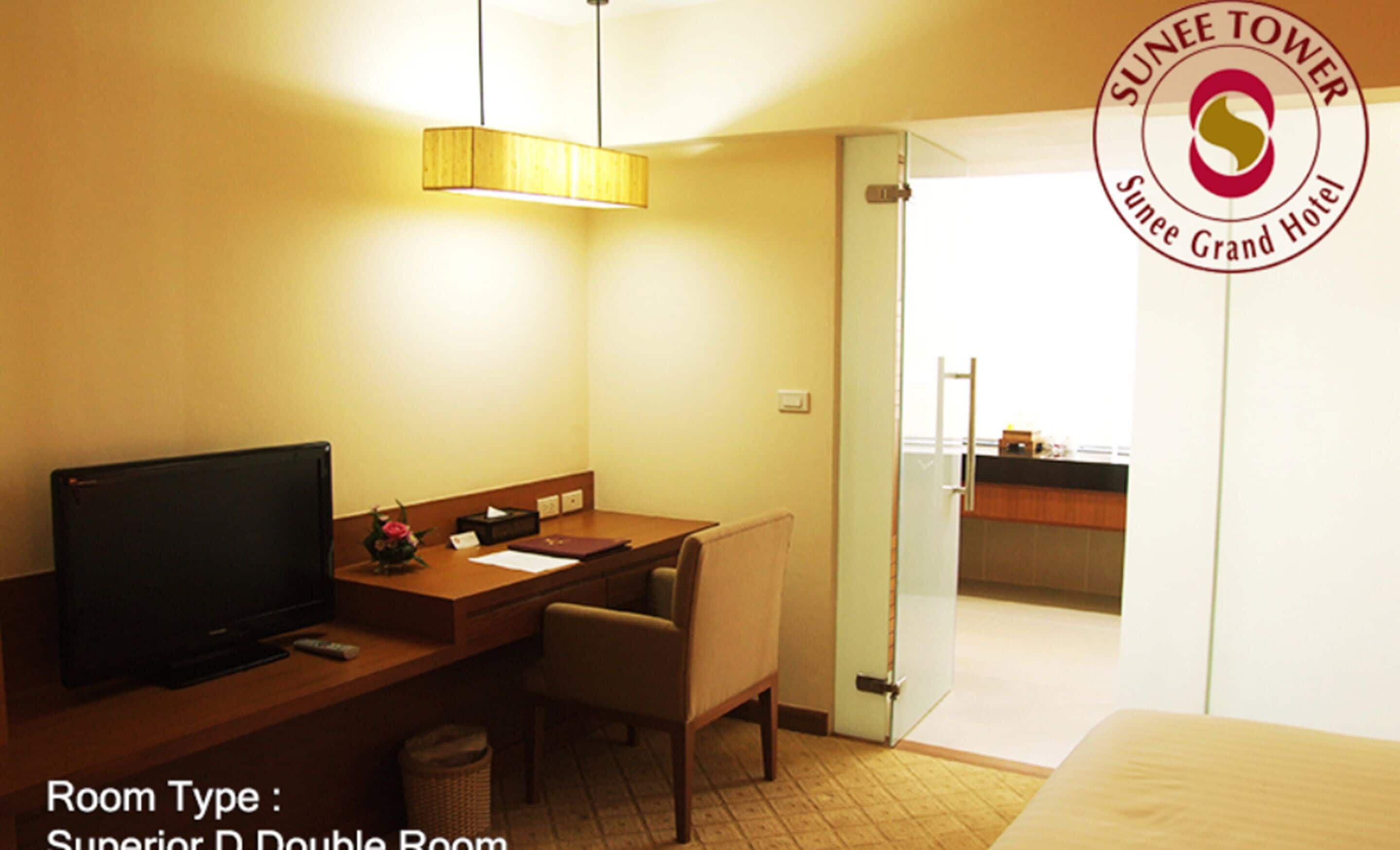 Habitación doble Superior D con televisor, escritorio, silla y vista al balcón.