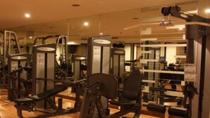 A gym with various exercise machines, mirrors, and a wooden floor. - Sunee Grand Hotel (Ubon Ratchathani)