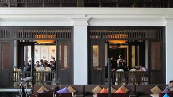 A hotel lobby with seating areas and a dining section.