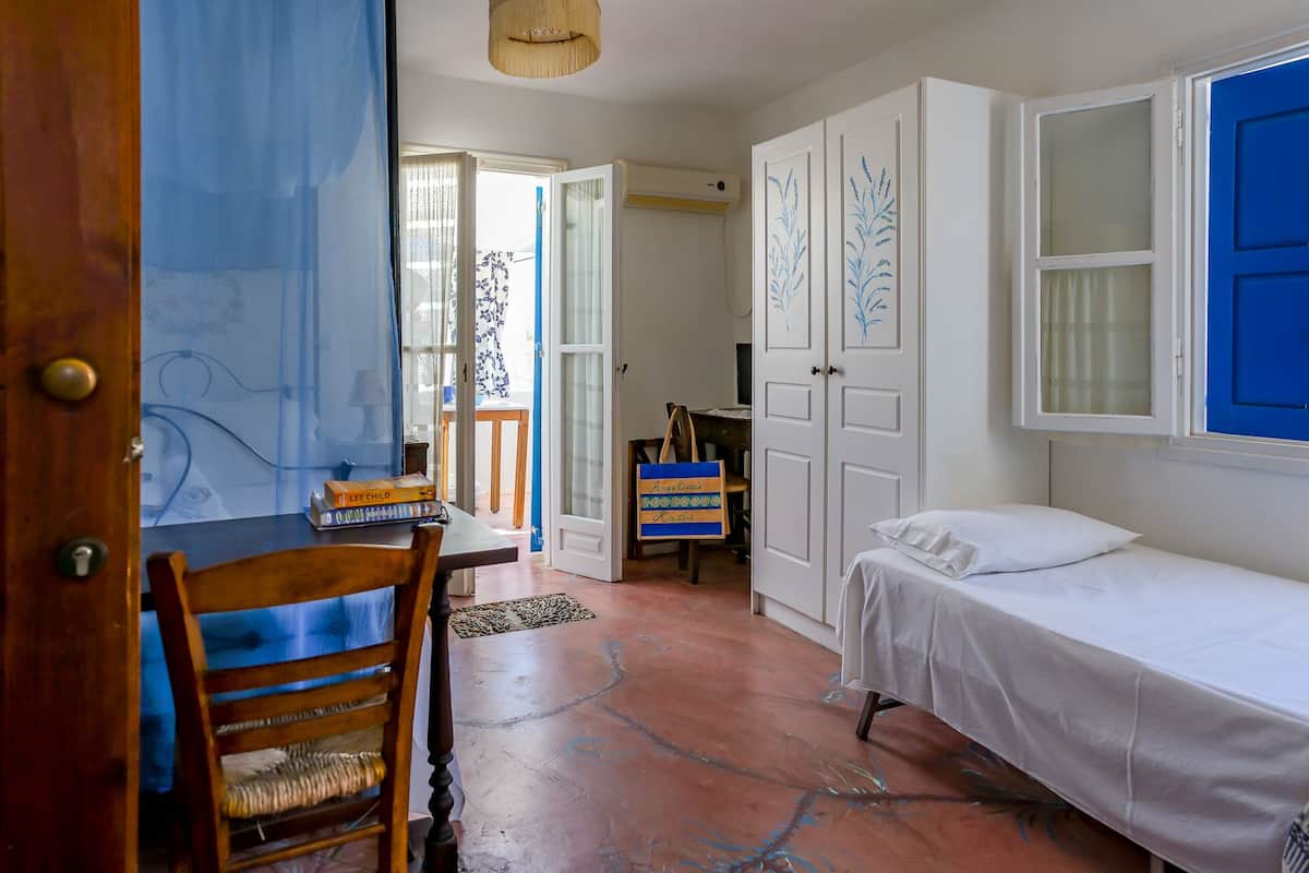 Una habitación con cama, escritorio, silla y armario.