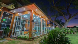 A modern building with large windows and a well-lit exterior. - Baan Suan Khunta Golf Resort (Warin Chamrap)