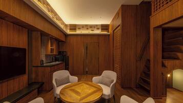 A modern interior with a wooden theme, a round wooden table, and white armchairs.