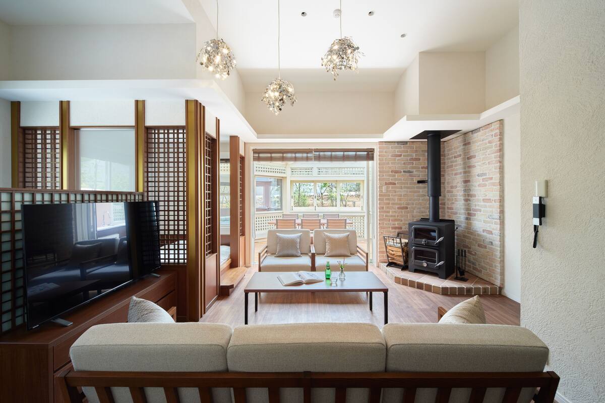 A modern living room with a sofa, TV, coffee table, and a fireplace.