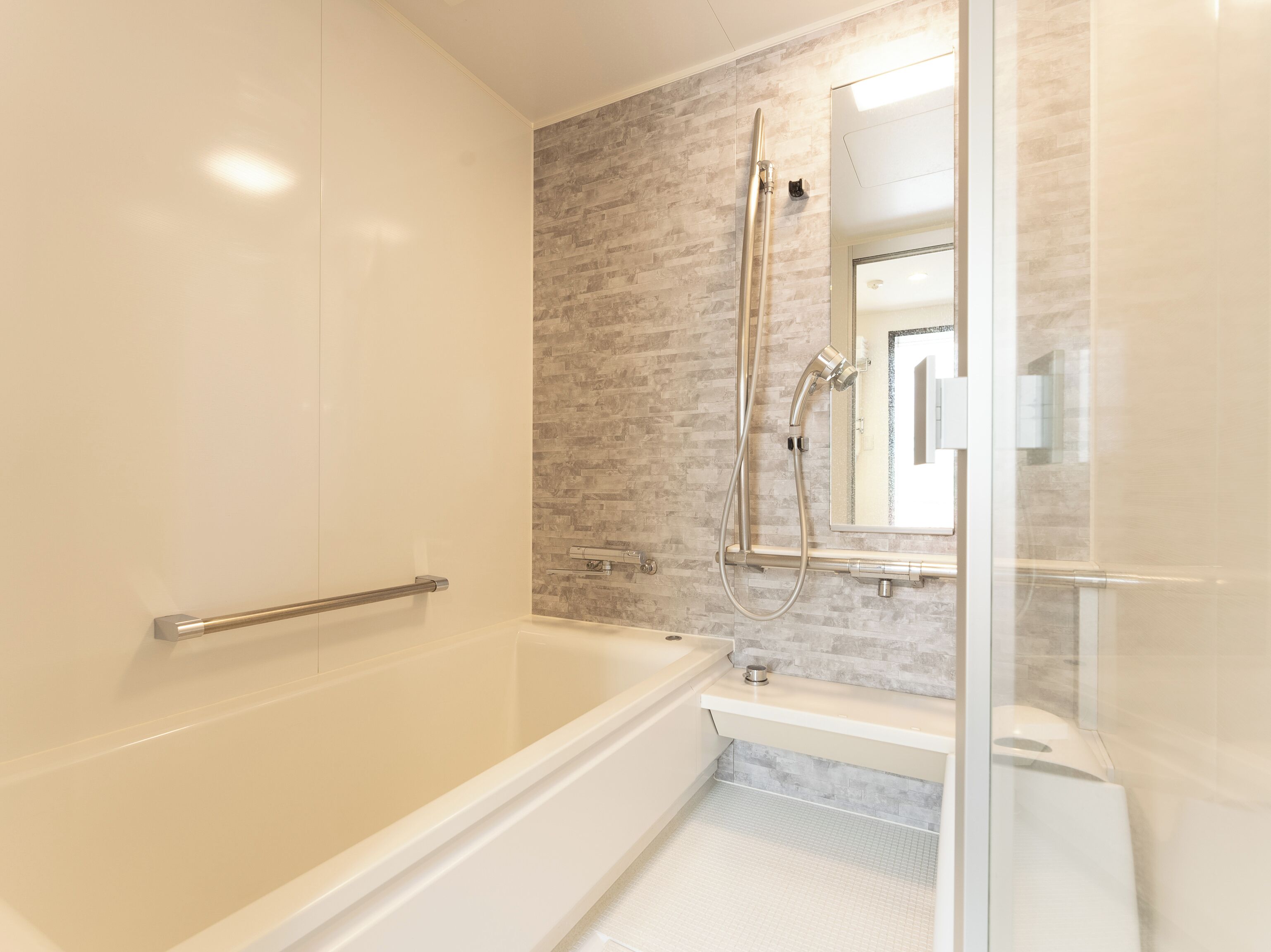 A modern bathroom with a bathtub, a shower, and a glass-enclosed shower area.