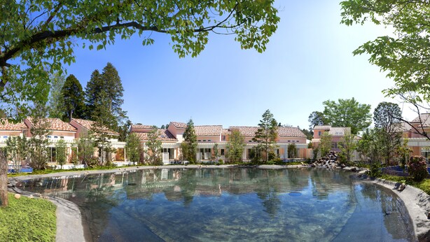A courtyard with a clear pool, surrounded by buildings with red-tiled roofs and a clear blue sky. - Koyaru-no-sato Doggys Island (Yachimata)