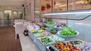 A buffet with various food items and a seating area with tables. - Koyaru-no-sato Doggys Island (Yachimata)