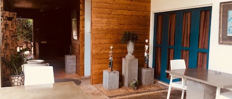 Un interior de madera con suelo de hormigón, muebles blancos y una puerta azul.
