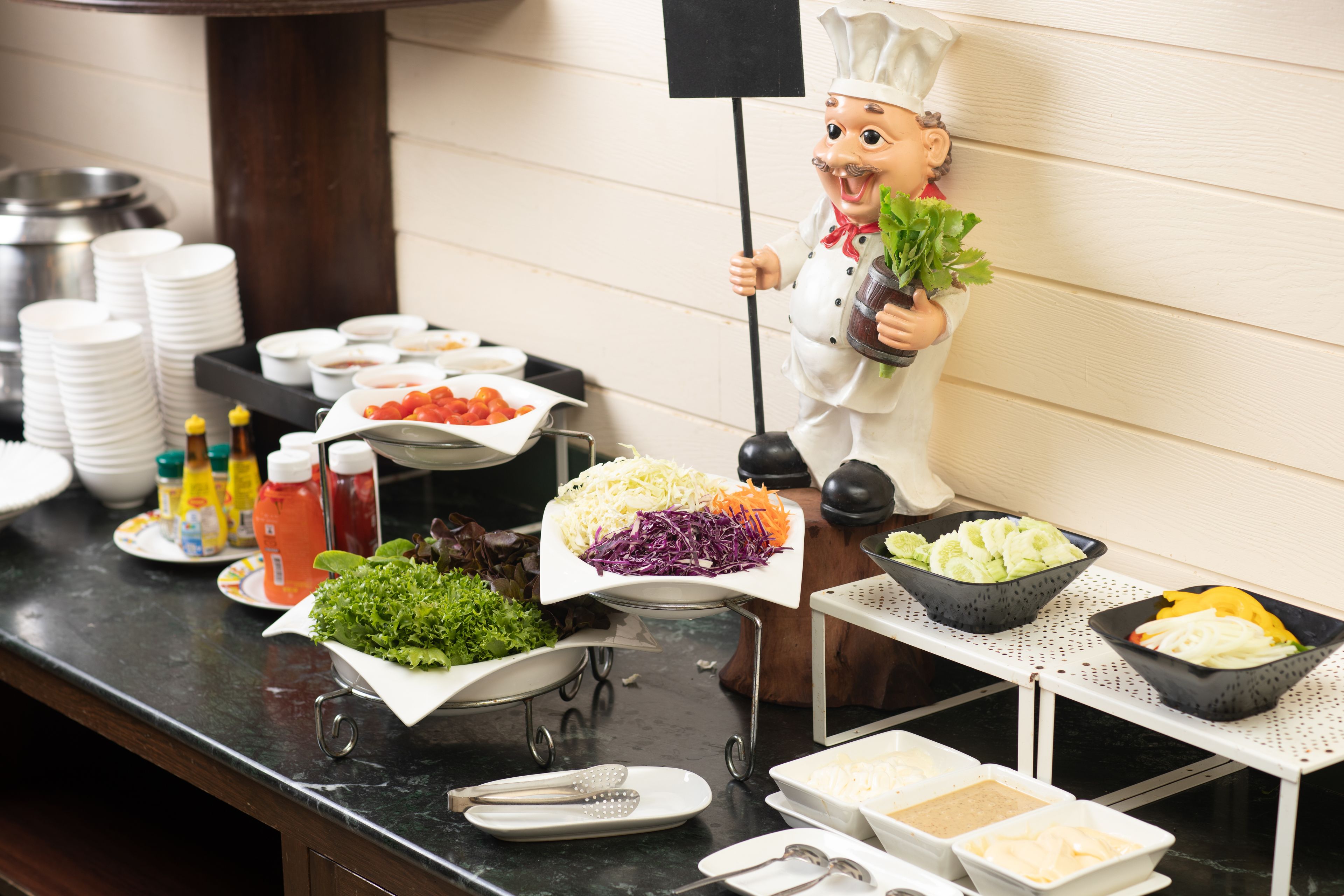 A buffet setup with various food items and condiments.