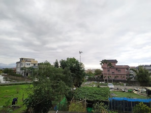 A residential area with modern buildings, a green field, and a clear sky. - Tesla Charging Kimura Elevator B&B (Luodong)